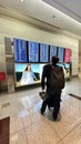 DUBAI,UNITED ARAB EMIRATES.15 SEPTEMBER 2023.Man with luggage, walking in Dubai Airport, checking flight info board