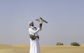 Falconer training his bird in a desert