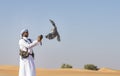 Falconer is training Peregrine Falcon in a desert near Dubai