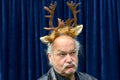 Dubious man wearing gold reindeer antlers