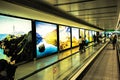 Dublin Airport people, passengers travelling with suitcases on walkway escalator in motion with highlighted images of Ireland in t