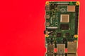 Beautiful closeup view of Raspberry Pi 4 Model B minicomputer on reflective red surface. Creative shot