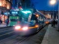 Dublin, Ireland - 20.12.2022: Busy traffic in the capital with double decker bus and Luas city tram in motion after dusk