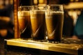 Selective focus on three pints of Guinness in glasses on bar or tap Royalty Free Stock Photo