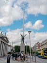 Dublin, Ireland - 07.22.2022: Group of tourists by Jim Larking monument. Warm sunny day