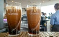 Two pints of Guinness on a stand almost ready to drink inside the Guinness Storehouse