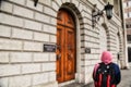 DUBLIN, IRELAND-- MAY 28, 2012: Muslim woman passing by Bank of Ireland wooden door