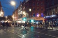 Dublin, Ireland - 12.11.2021: Night scene. Crowd of people walking towards Grafton street. City lights and traffic. Soft and Royalty Free Stock Photo