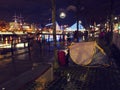 Dublin, Ireland - 12.11.2021: Night scene. Homeless tents by river Liffey. Samuel Beckett Bridge illuminated for Christmas in the