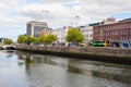 Dublin, Ireland - 08.25.2022: River Liffey and old buildings. Three tall cranes in the background. Warm sunny day. Capital