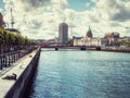 Dublin, Ireland - 07.12.2023: River Liffey and Old Custom building. Warm sunny day. Cloudy sky. City center and popular tourist