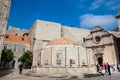 Tourists at the Large Onofrio Fountain located at Stradun street in the old town of Dubrovnik Royalty Free Stock Photo