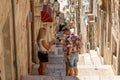 Dubrovnik, Croatia - Aug 20, 2020: Lost tourist with mask ask for information on ston stairs to old town in summer