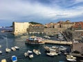 A view from outside the Walls of Dubrovnik looking at the bay full of boats and a long portion of the wall,