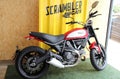 Ducati Scrambler icon: side view of a custom motorcycle, colored red
