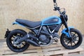 Ducati Scrambler icon: side view of motorcycle, custom blue color