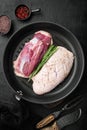 Duck breast raw fillet meat, on frying cast iron pan, on black stone background, top view flat lay Royalty Free Stock Photo