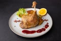 Duck leg confit with Brussels sprouts, baked potatoes, thyme, orange and lingonberry sauce. Traditional French cuisine. Royalty Free Stock Photo