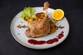 Duck leg confit with Brussels sprouts, baked potatoes, thyme, orange and lingonberry sauce. Traditional French cuisine. Selective Royalty Free Stock Photo