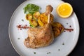 Duck leg confit with Brussels sprouts, baked potatoes, thyme and orange. Traditional French cuisine. Selective focus. Royalty Free Stock Photo