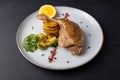 Duck leg confit with Brussels sprouts, baked potatoes, thyme and orange. Traditional French cuisine. Royalty Free Stock Photo