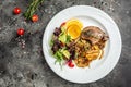 Duck leg confit meat portion of prepared with baked potatoes, mushrooms and onions, top view Royalty Free Stock Photo