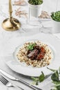 Duck liver fuagra and rice with sauce at the white plate on light marble background. Healthy sea food, hard light, restaurant