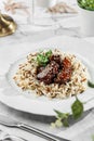 Duck liver fuagra and rice with sauce at the white plate on light marble background. Healthy sea food, hard light, restaurant