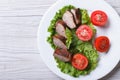 Duck meat fried with tomatoes close-up from above. horizontal Royalty Free Stock Photo