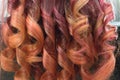 Background of bright curled locks of long hair with glitter from crimson to red