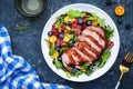 Duck salad with grilled breast with red orange, kumquat, blueberry and chard, frisse, mizuna and arugula leaves on blue table Royalty Free Stock Photo