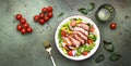 Duck salad with grilled breast and vegetables: red tomato, cucumber, paprika, onoin and chard, frisse, mizuna and arugula leaves Royalty Free Stock Photo