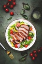 Duck salad with grilled breast and vegetables: red tomato, cucumber, paprika, onoin and chard, frisse, mizuna and arugula leaves Royalty Free Stock Photo