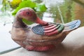 Duck statue made from wood standing in a pool