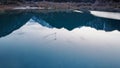 Ducks swim on a mirrored smooth mountain lake