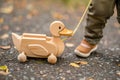 duckshaped wooden pull toy being walked by a toddler Royalty Free Stock Photo