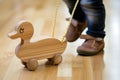 duckshaped wooden pull toy being walked by a toddler Royalty Free Stock Photo