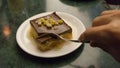 Dude taking with a fork orange dessert with syrup in restaurant. Homemade cake with chocolate on a plate