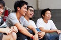 Dude, thats awesome. A group of asian youths laughing together while sitting outdoors.