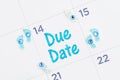 Due Date message on a monthly calendar with tiny baby footprints , bottle and rattle