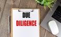 DUE DILIGENCE text on clipboard paper with laptop, mouse and pen Royalty Free Stock Photo