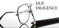 DUE DILIGENCE text. Glasses and pencil isolated on the white background