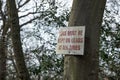 Impromptu Dog Owner warning sign seen attached high up on a forest tree. Royalty Free Stock Photo