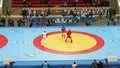 Duelling on combat sambo between male paricipants. Referees, cameramen, and coaches are on backgorund.