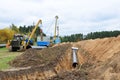 A Dug trench in the ground for the installation and installation of industrial gas and oil pipes. t.Crawler crane with side boom Royalty Free Stock Photo