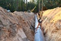 A Dug trench in the ground for the installation and installation of industrial gas and oil pipes. t.Crawler crane with side boom Royalty Free Stock Photo