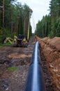 A Dug trench in the ground for the installation and installation of industrial gas and oil pipes. t.Crawler crane with side boom Royalty Free Stock Photo