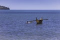 A dugout canoe drifting in the shallow water off an island