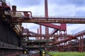 A bridge spans a busy industrial landscape, connecting the coking plant to bustling transportation networks in the cloudy sky