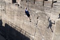 Duisburg Germany - february 2nd 2018 - Climber male hanging on ropes climbing towards a wall with a shadow